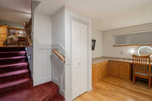 Kitchen with tile countertops, brown cabinetry, and light wood finished floors