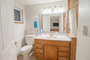 Full bathroom with a shower with shower curtain, vanity, and light tile patterned floors