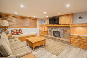Living area featuring recessed lighting, light wood-style flooring, and a fireplace