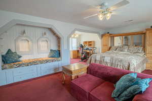 Carpeted bedroom with a textured ceiling, an office area, and ceiling fan