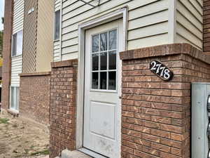 View of exterior entry with brick siding