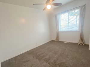 Carpeted spare room featuring baseboards