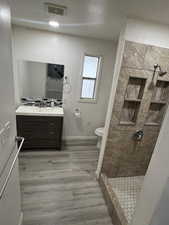 Bathroom featuring vanity, a stall shower, and light wood-type flooring