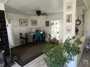Interior space with an office area, wood finished floors, and a ceiling fan