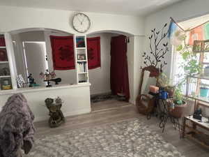 Living area featuring light wood-style floors and arched walkways