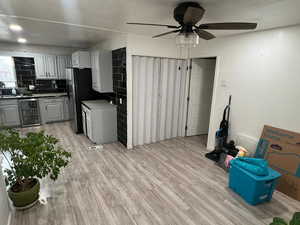 Kitchen with gray cabinetry, wine cooler, light wood finished floors, and light countertops