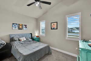 Bedroom with vaulted ceiling, carpet flooring, and a ceiling fan