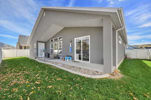 Rear view of house with a fenced backyard, stucco siding, and a patio