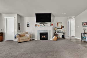 Living area with a tile fireplace and carpet flooring