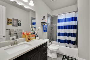 Full bathroom featuring shower / bath combo, vanity, and tile patterned flooring