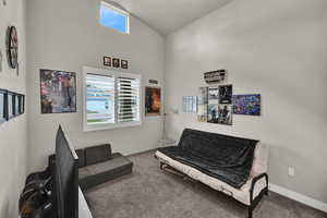 Sitting room featuring carpet and high vaulted ceiling