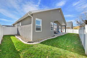 Rear view of property featuring a fenced backyard, stucco siding, and a patio