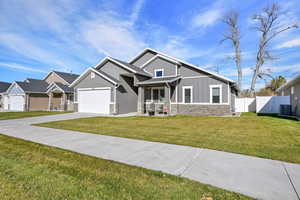 Craftsman-style home featuring stone siding, board and batten siding, concrete driveway, and an attached garage