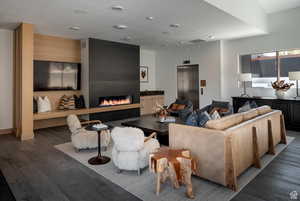 Living room featuring wood finished floors, elevator, and a fireplace