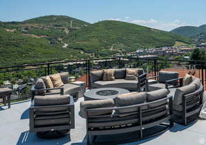 View of patio / terrace featuring an outdoor living space with a fire pit and a mountain view