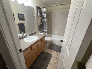 Bathroom with vanity, light tile patterned flooring, and shower / bathtub combination with curtain