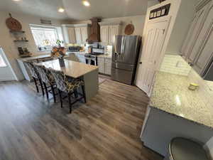 Kitchen featuring backsplash, a breakfast bar, stainless steel appliances, light stone countertops, and recessed lighting