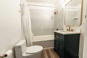 Full bath featuring vanity, shower / bath combination with curtain, and wood finished floors