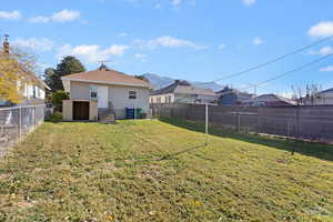 Rear view of property featuring a fenced backyard, a residential view, and an outbuilding