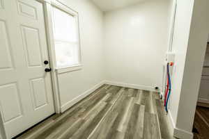 Laundry area featuring baseboards and light wood-type flooring
