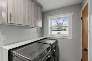 Washroom featuring cabinet space and separate washer and dryer