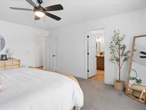 Bedroom with ceiling fan, carpet flooring, and connected bathroom