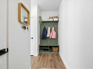 Mudroom featuring light wood-style floors and baseboards