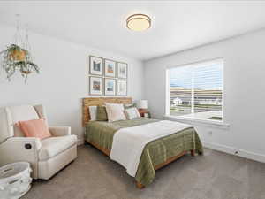 Bedroom featuring carpet and baseboards