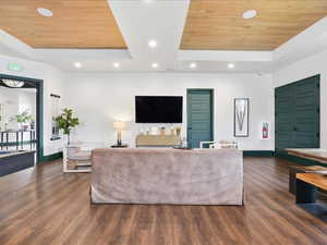 Living room featuring a tray ceiling, wood ceiling, dark wood finished floors, and recessed lighting