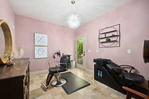 Workout room with a chandelier and stone tile flooring
