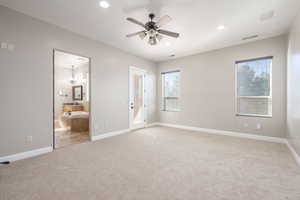 Unfurnished bedroom featuring ceiling fan, light carpet, recessed lighting, ensuite bath, and a chandelier