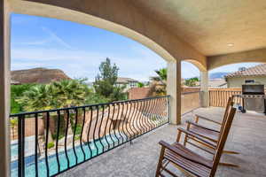 Balcony with grilling area, view of pool, and a mountain view