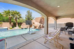 View of swimming pool featuring a patio, a fenced backyard, a pool with connected hot tub, and a water slide