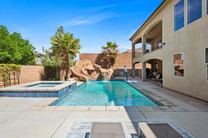 View of swimming pool with a patio area, a fenced backyard, a balcony, and a pool with connected hot tub