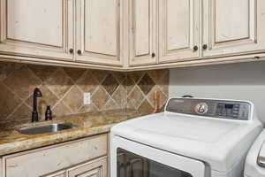 Laundry area featuring washer / clothes dryer and cabinet space