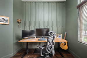 Home office with dark wood-style floors and baseboards