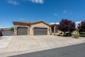 Mediterranean / spanish house featuring a garage, stucco siding, stone siding, driveway, and a tiled roof