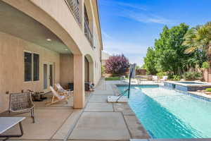 View of swimming pool featuring a patio area and a pool with connected hot tub