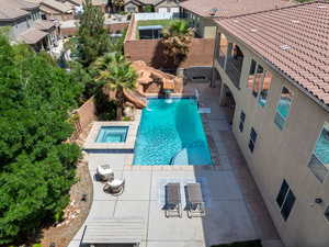View of pool featuring a patio area, a fenced backyard, a residential view, and a pool with connected hot tub