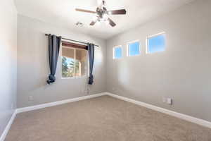 Carpeted spare room with baseboards and a ceiling fan