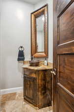 Half bathroom with vanity and baseboards
