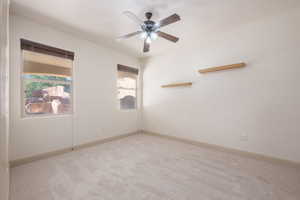 Empty room with carpet flooring and a ceiling fan