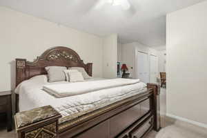 Bedroom featuring light colored carpet, a closet, and ceiling fan