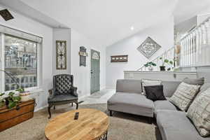 Carpeted living area featuring lofted ceiling, recessed lighting, and tile patterned floors
