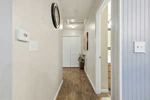 Corridor with dark wood-style floors and attic access