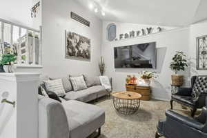 Carpeted living area featuring vaulted ceiling