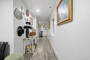 Hall featuring wood finished floors and recessed lighting