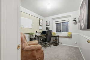 Office space featuring carpet and a textured ceiling