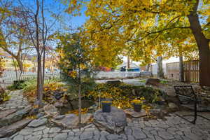 Fenced backyard featuring a garden pond and a patio area