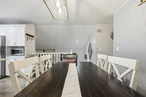 Dining space featuring lofted ceiling and light wood-style floors